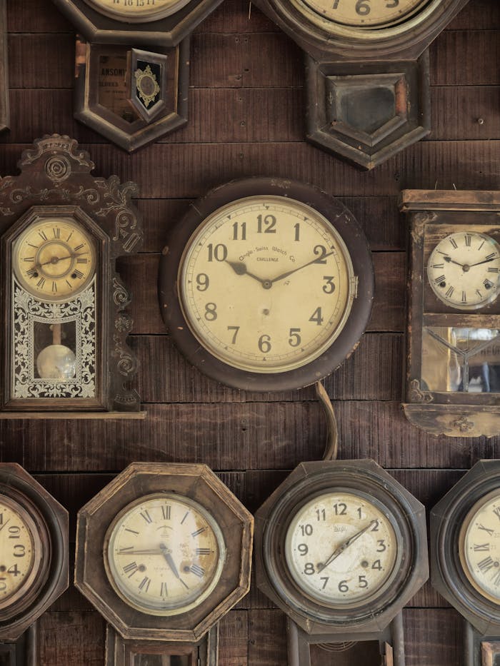 services-01 A collection of antique wall clocks displayed in a rustic setting, capturing nostalgic vintage charm.