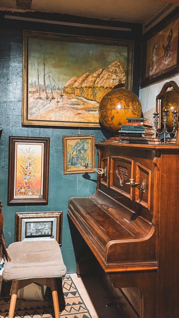 services-03 Cozy vintage room featuring a wooden piano, art, and globe.