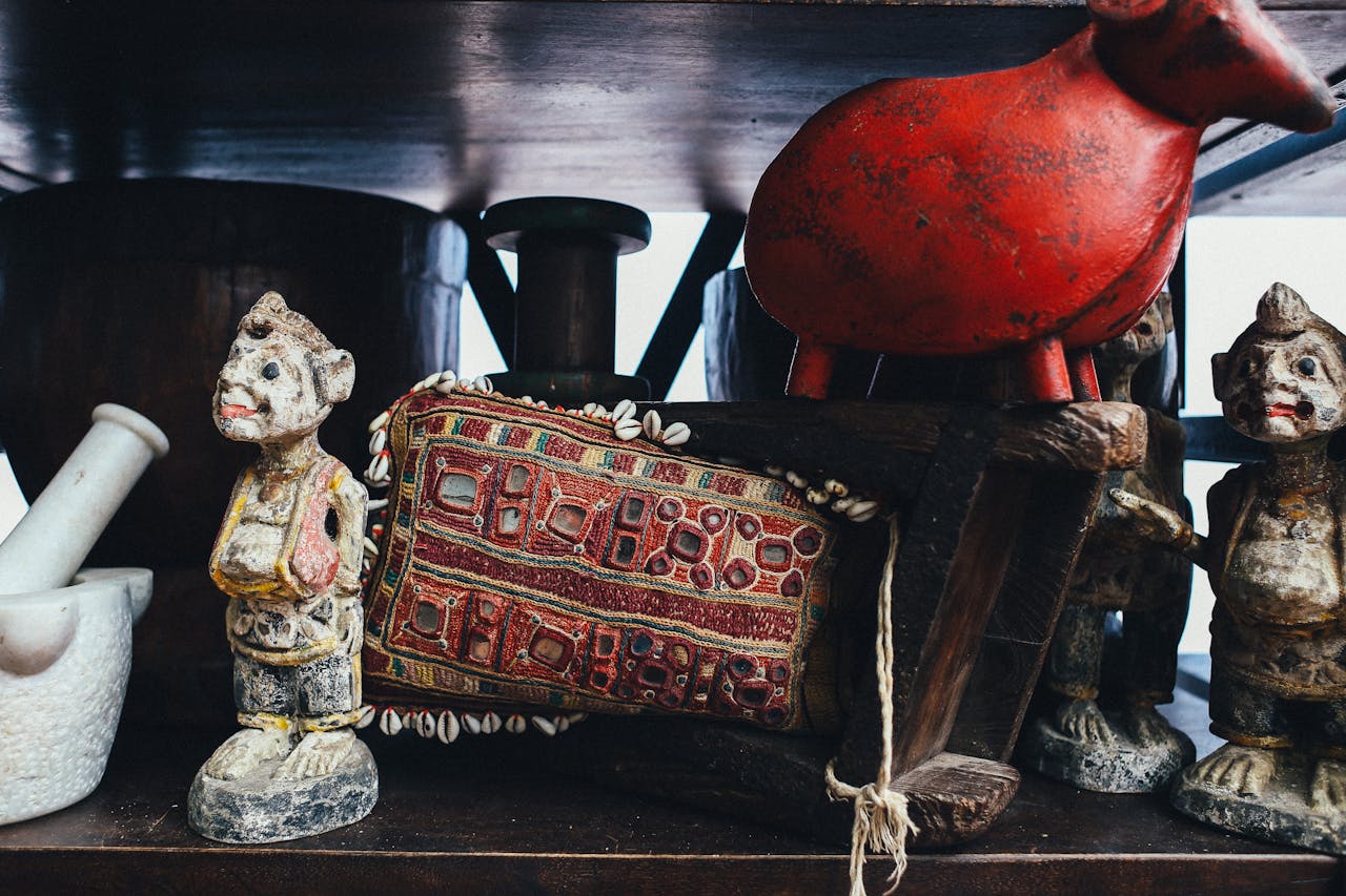 A collection of antique figurines and decorative objects on a shelf. Perfect for historical exhibits.