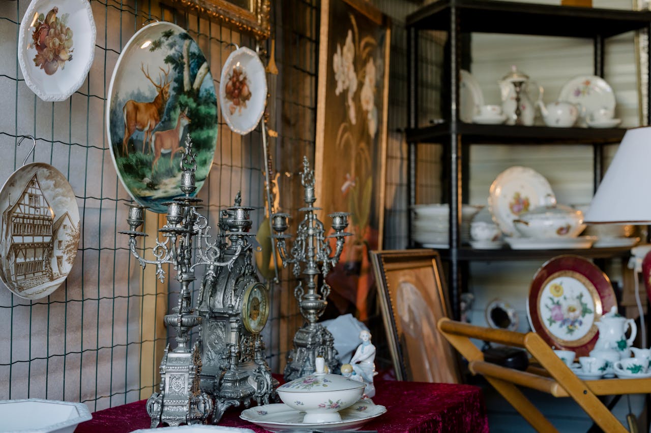 ours-journey Charming assortment of vintage plates, candelabras, and tableware on display indoors.